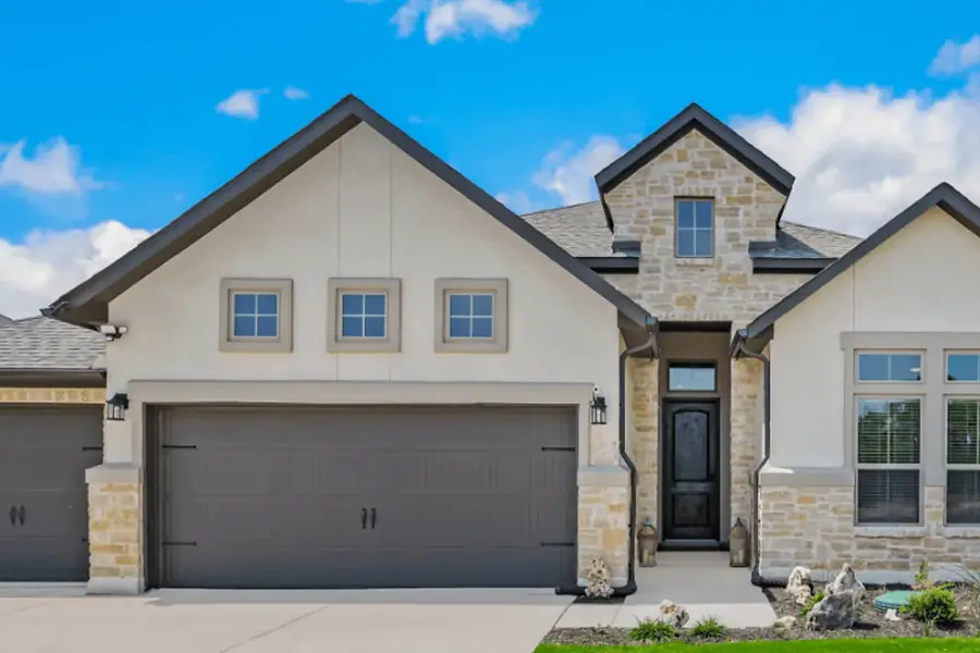 Single-story home with newly painted stucco siding, trim, and garage doors