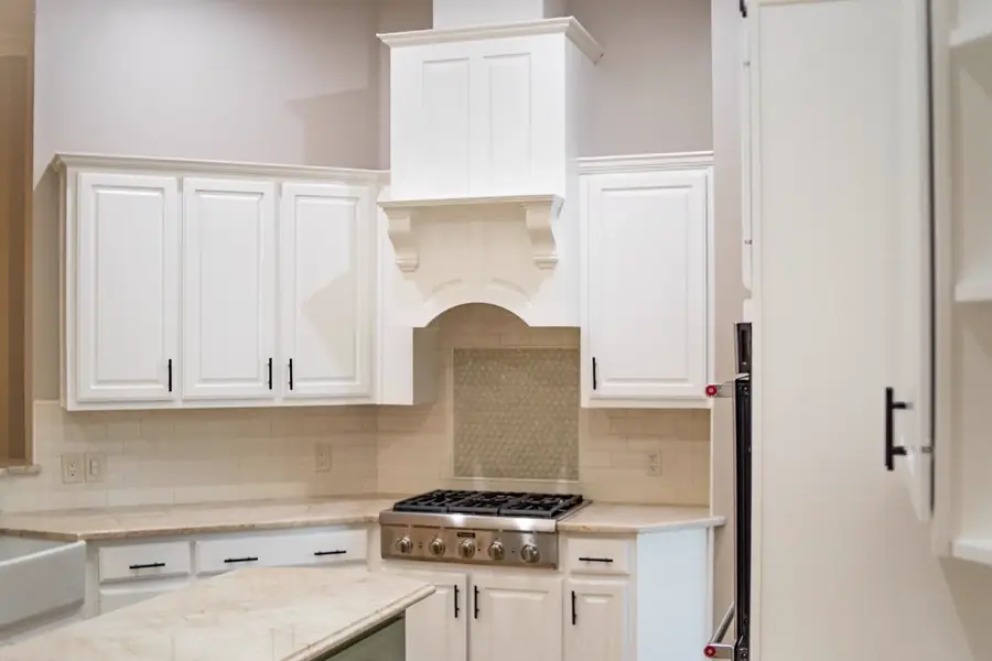 Painted white kitchen cabinetry and range hood in a Knoxville home